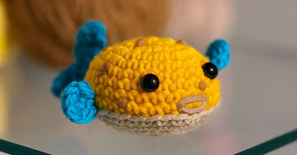 Peixe amigurumi colorido feito em crochê com barbante amarelo e barbante azul, ideal como chaveiro artesanal passo a passo.